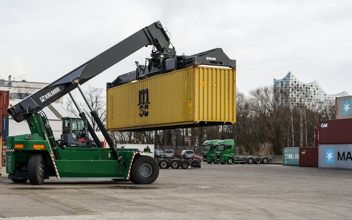 A reach stacker lifting a shipping container in a container yard